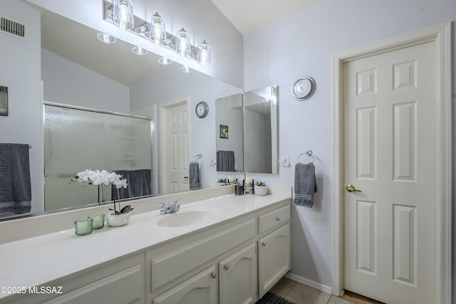 bathroom with tile patterned flooring, vanity, and a shower with shower door