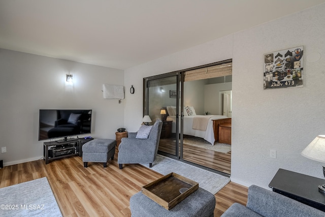 sitting room with ceiling fan, lofted ceiling, and light wood-type flooring