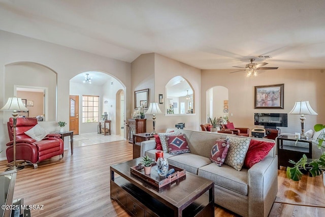 living room with light hardwood / wood-style floors, ceiling fan, and lofted ceiling