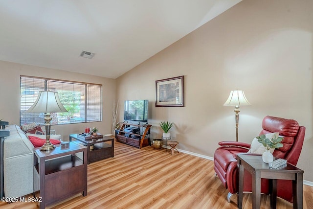 living room with hardwood / wood-style flooring and vaulted ceiling