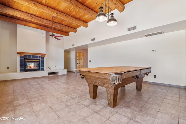 recreation room with a tile fireplace, ceiling fan, beamed ceiling, wood ceiling, and pool table