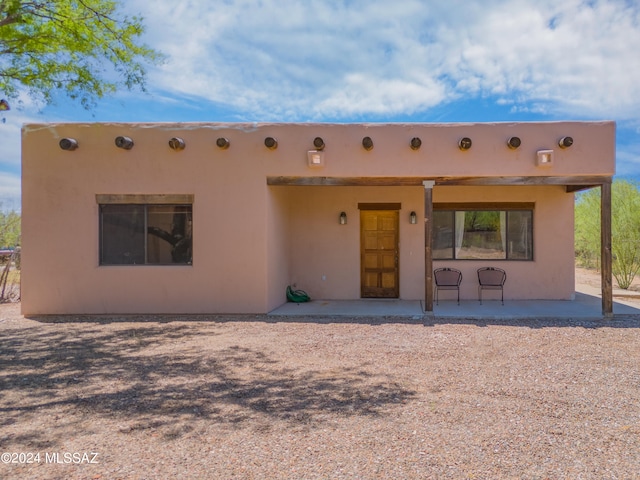 pueblo revival-style home featuring a patio area