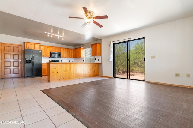 kitchen with black appliances, ceiling fan, kitchen peninsula, and light tile patterned floors