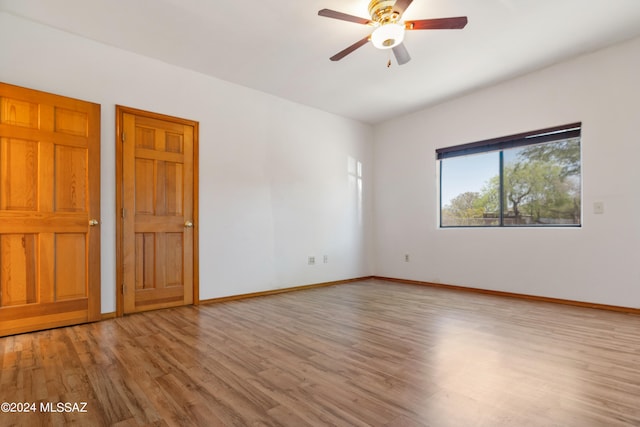 empty room with light hardwood / wood-style flooring and ceiling fan