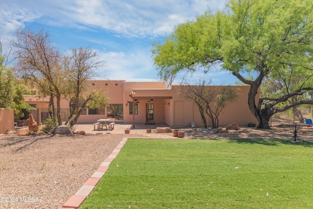 adobe home featuring a patio area and a front lawn