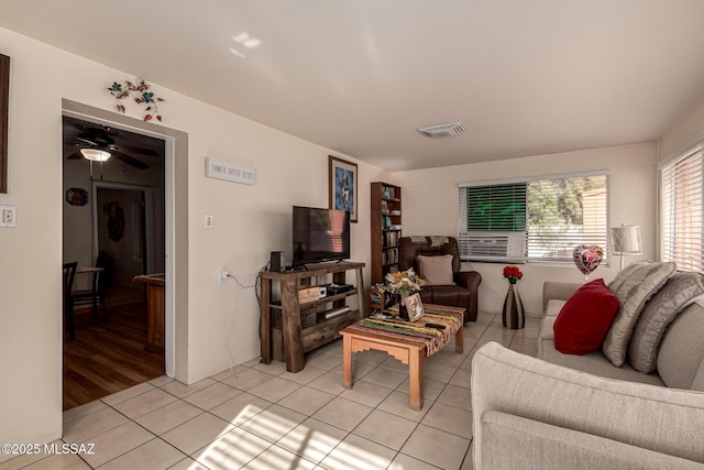 tiled living room with ceiling fan