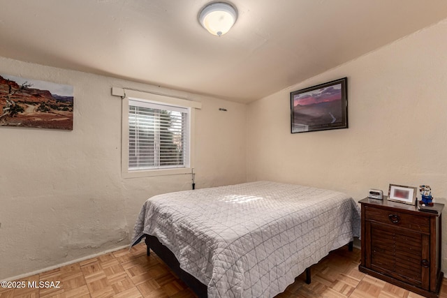 bedroom featuring lofted ceiling and light parquet flooring