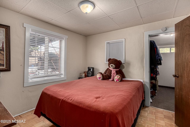 bedroom with multiple windows and light parquet floors