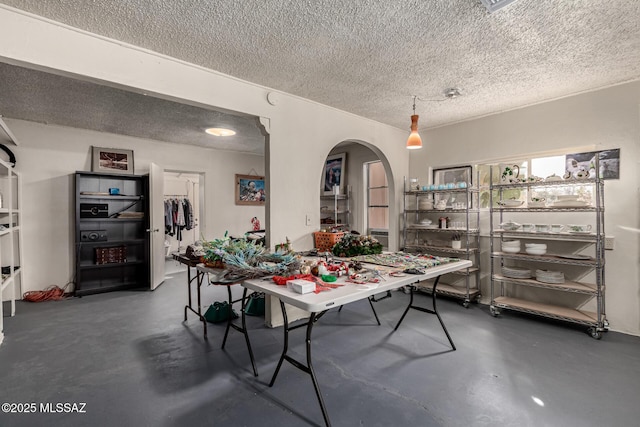 dining space featuring a textured ceiling and concrete flooring