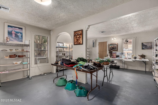 interior space with a textured ceiling, cooling unit, and concrete flooring