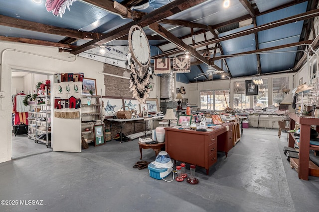 misc room featuring a workshop area, vaulted ceiling, and concrete flooring