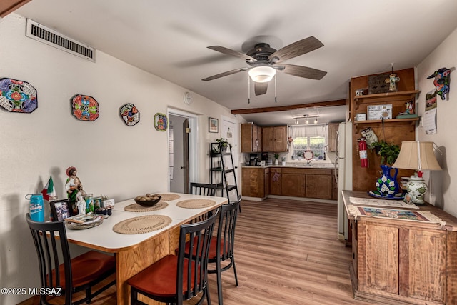 dining space with light wood-type flooring and ceiling fan