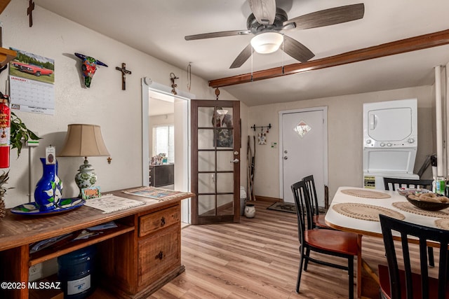 dining room with stacked washing maching and dryer, ceiling fan, vaulted ceiling with beams, and light hardwood / wood-style flooring