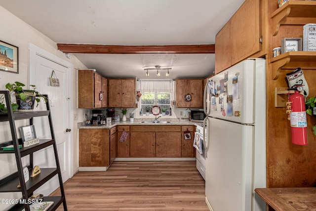 kitchen featuring sink, white fridge, light hardwood / wood-style flooring, track lighting, and range