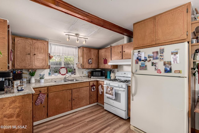 kitchen with white appliances, light hardwood / wood-style flooring, vaulted ceiling, and sink