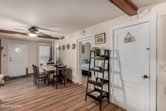 dining area featuring beam ceiling, ceiling fan, light wood-type flooring, and stacked washer and dryer