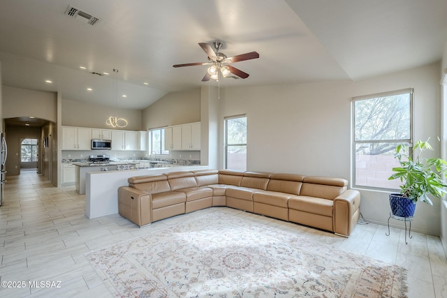 living room featuring ceiling fan, a healthy amount of sunlight, and high vaulted ceiling