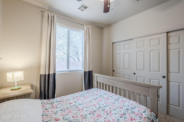 carpeted bedroom with ceiling fan and a closet