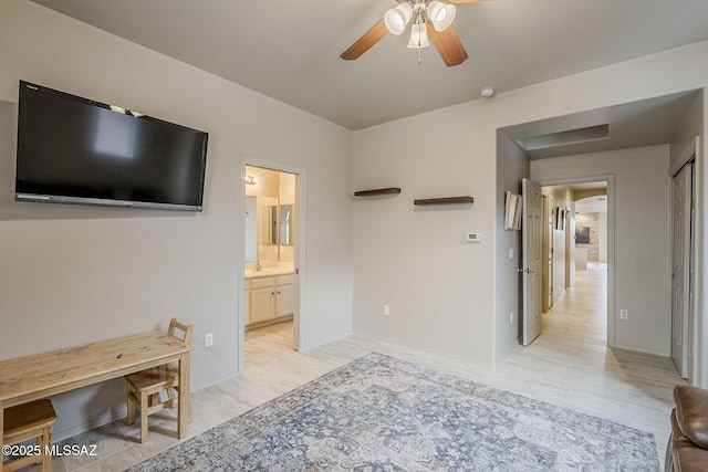 bedroom featuring light wood-type flooring, ensuite bathroom, and ceiling fan