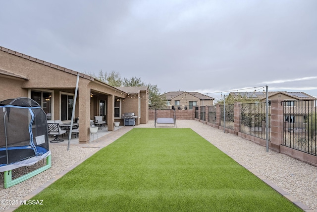 view of yard featuring a patio and a trampoline