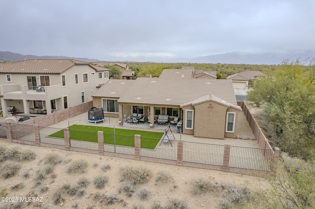 rear view of house featuring a patio and a trampoline