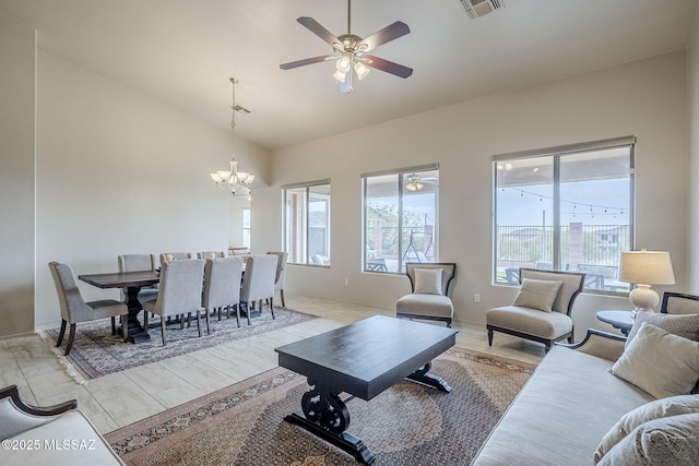 living room featuring lofted ceiling, light hardwood / wood-style flooring, and ceiling fan with notable chandelier