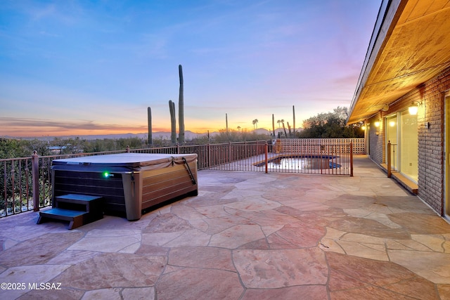 patio terrace at dusk with a hot tub