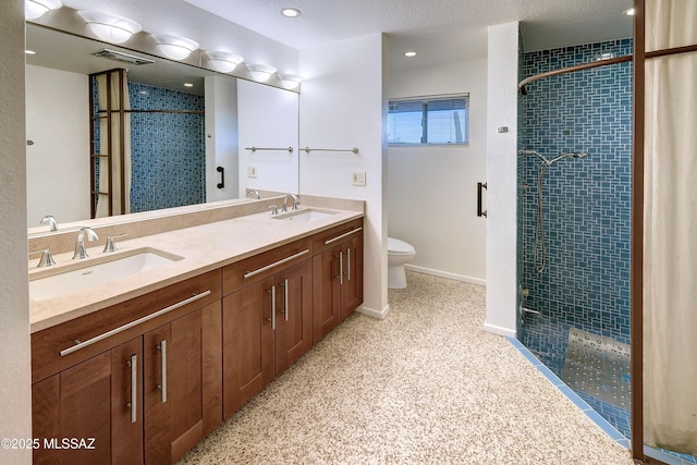 bathroom with vanity, toilet, and a shower with door