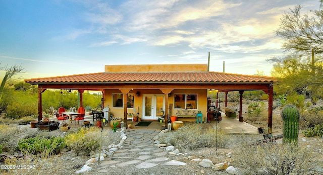 back house at dusk with a patio area