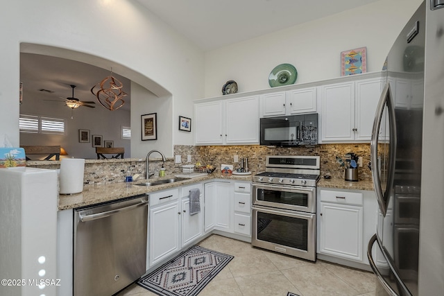 kitchen featuring appliances with stainless steel finishes, backsplash, ceiling fan, sink, and white cabinets