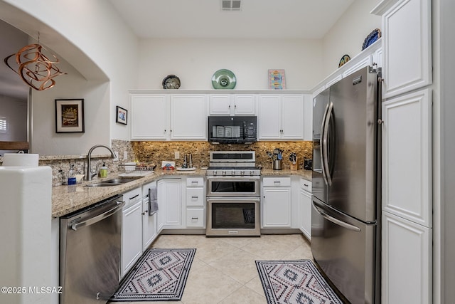 kitchen with backsplash, white cabinets, sink, light stone countertops, and appliances with stainless steel finishes