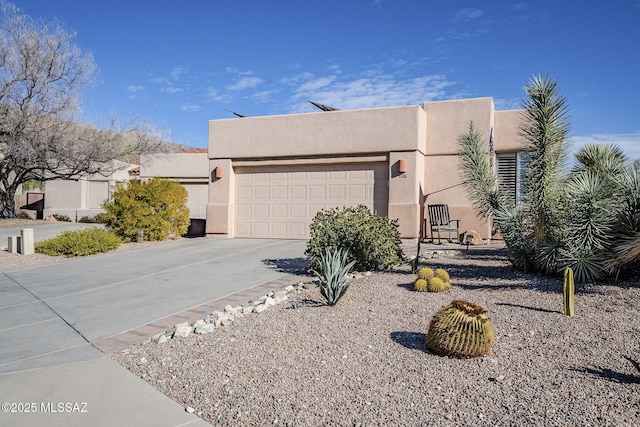 pueblo revival-style home featuring a garage