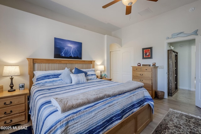 bedroom featuring ceiling fan, a closet, and light hardwood / wood-style flooring