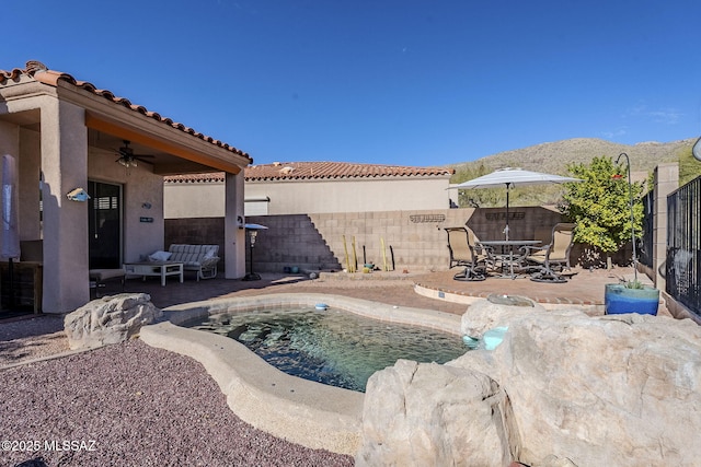 view of swimming pool featuring a mountain view, outdoor lounge area, a patio, and ceiling fan