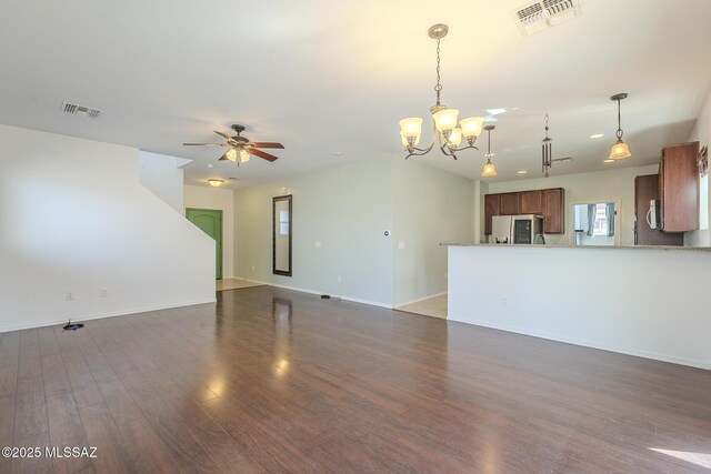 unfurnished living room with dark hardwood / wood-style flooring and ceiling fan with notable chandelier