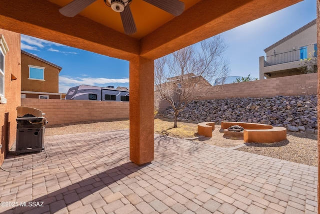 view of patio featuring an outdoor fire pit, a grill, ceiling fan, and a fenced backyard