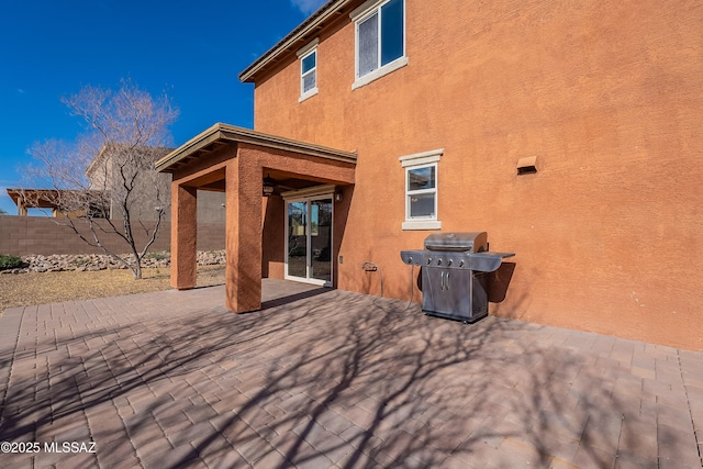 back of house with ceiling fan, a patio, fence, and stucco siding