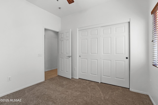 unfurnished bedroom with carpet floors, a closet, and ceiling fan