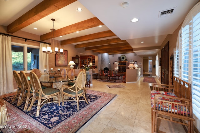 dining space featuring beamed ceiling, a brick fireplace, and an inviting chandelier