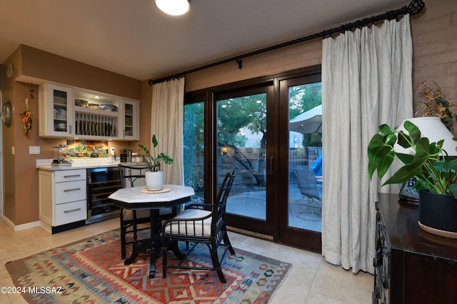 dining space featuring light tile patterned floors, beverage cooler, and indoor bar