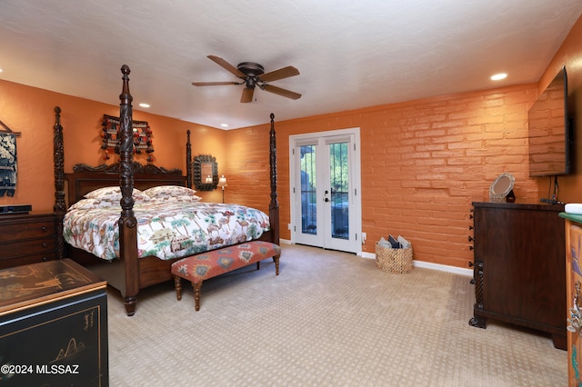 bedroom featuring access to exterior, french doors, brick wall, light colored carpet, and ceiling fan