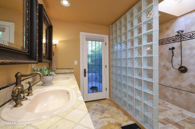 bathroom featuring a tile shower and vanity