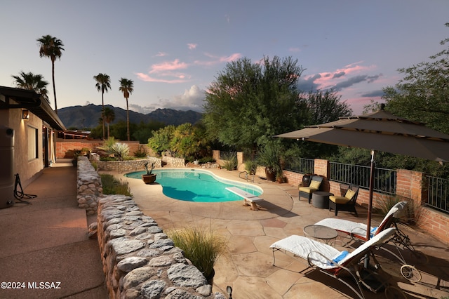 pool at dusk with a mountain view and a patio