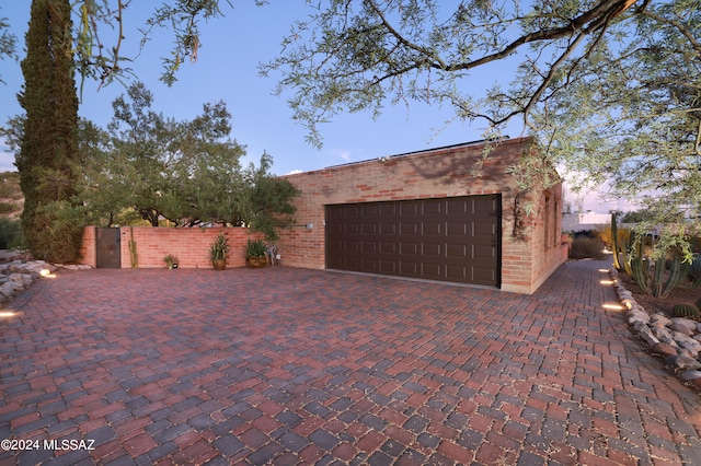 view of garage at dusk