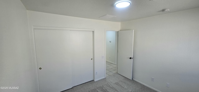 unfurnished bedroom with light carpet and a closet