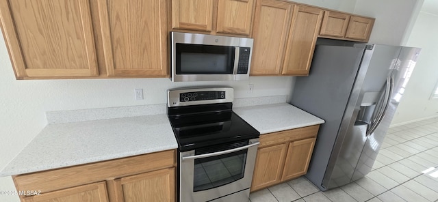 kitchen with light tile patterned floors and stainless steel appliances