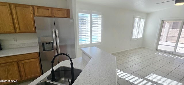 kitchen with ceiling fan, light tile patterned floors, sink, vaulted ceiling, and stainless steel fridge