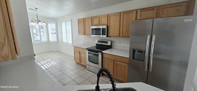 kitchen featuring vaulted ceiling, appliances with stainless steel finishes, decorative light fixtures, light tile patterned floors, and a notable chandelier