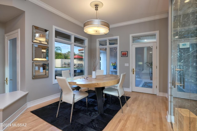 dining area featuring crown molding, french doors, and light wood-type flooring