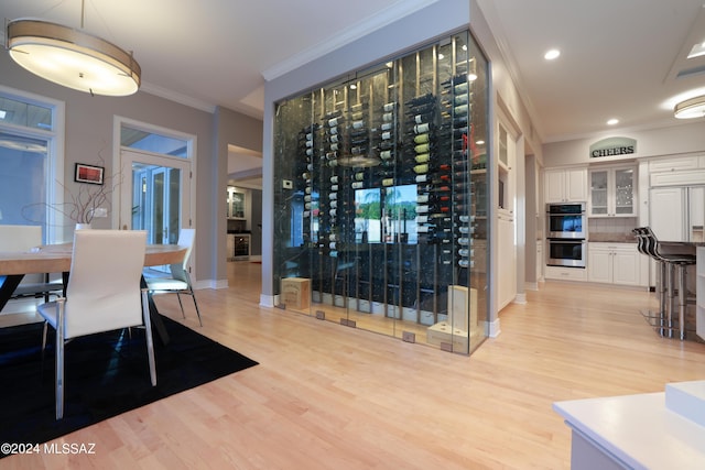 wine cellar featuring crown molding and light hardwood / wood-style floors